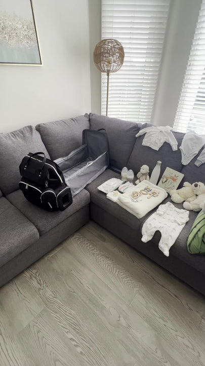 Video is displaying the diaper bag with  a bassinet being packed with baby essentials required when on the go. There are lots of storage, wet nap compartment with quick access, pockets for baby bottles. 